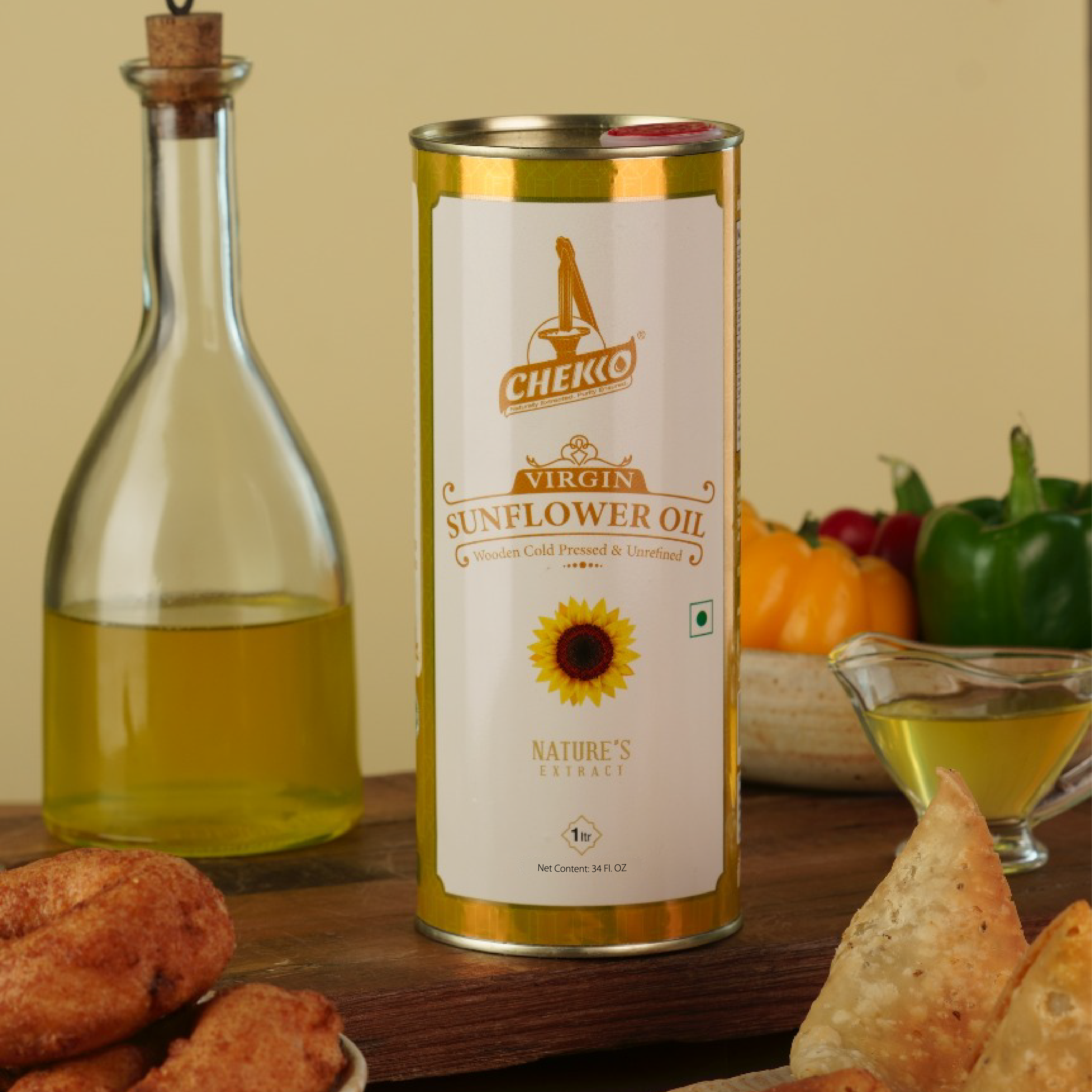 tin of chekko Virgin Sunflower Oil on a wooden table with fried snacks and a bottle of oil. | Naturally Extracted! Purity Ensured!