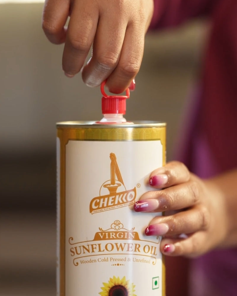 Can of Chekko Virgin Sunflower Oil with a hand opening it