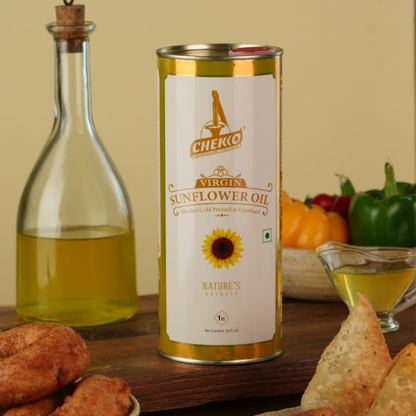tin of chekko Virgin Sunflower Oil on a wooden table with fried snacks and a bottle of oil. | Naturally Extracted! Purity Ensured!